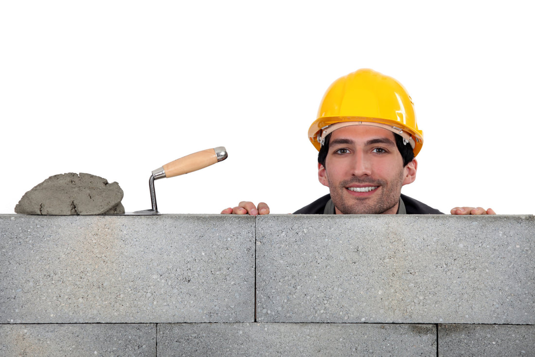 man working on putting concrete blocks