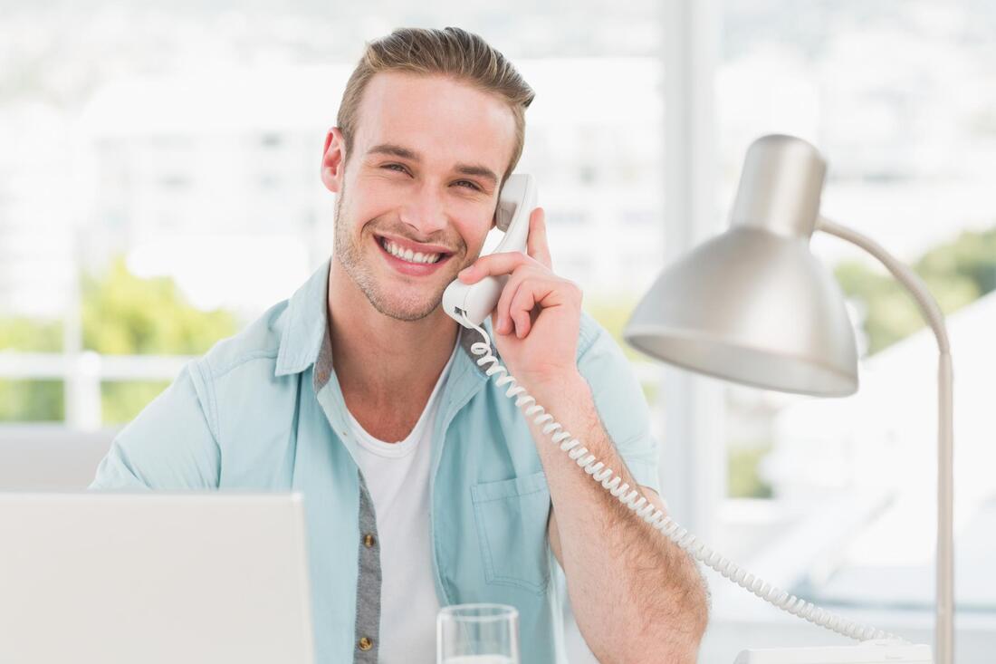 man smiling while talking to his phone